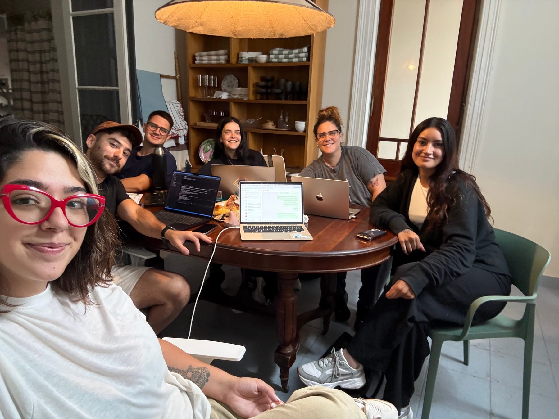 El equipo de Marea reunido alrededor de una mesa, sonriendo a cámara